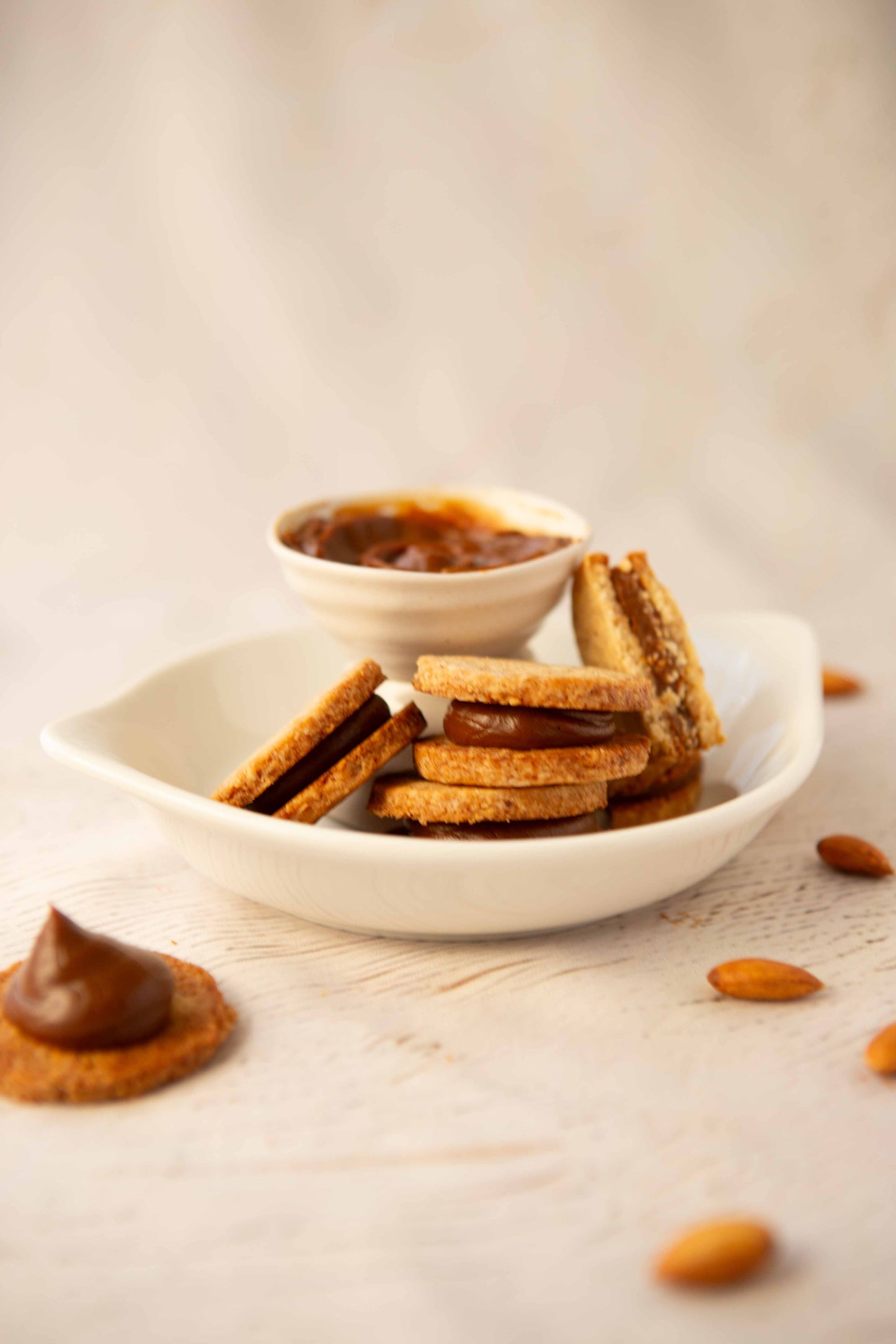 Almond alfajor served on a plate with dulce de leche.