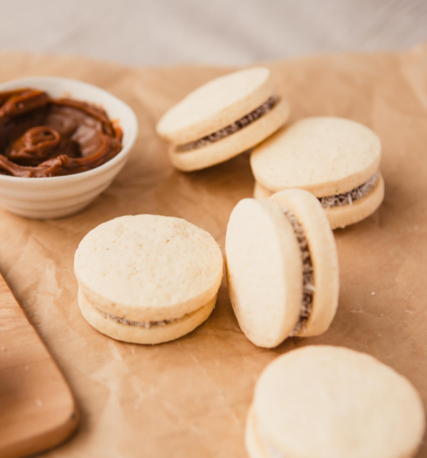 Traditional alfajores with a small pot of dulce de leche.