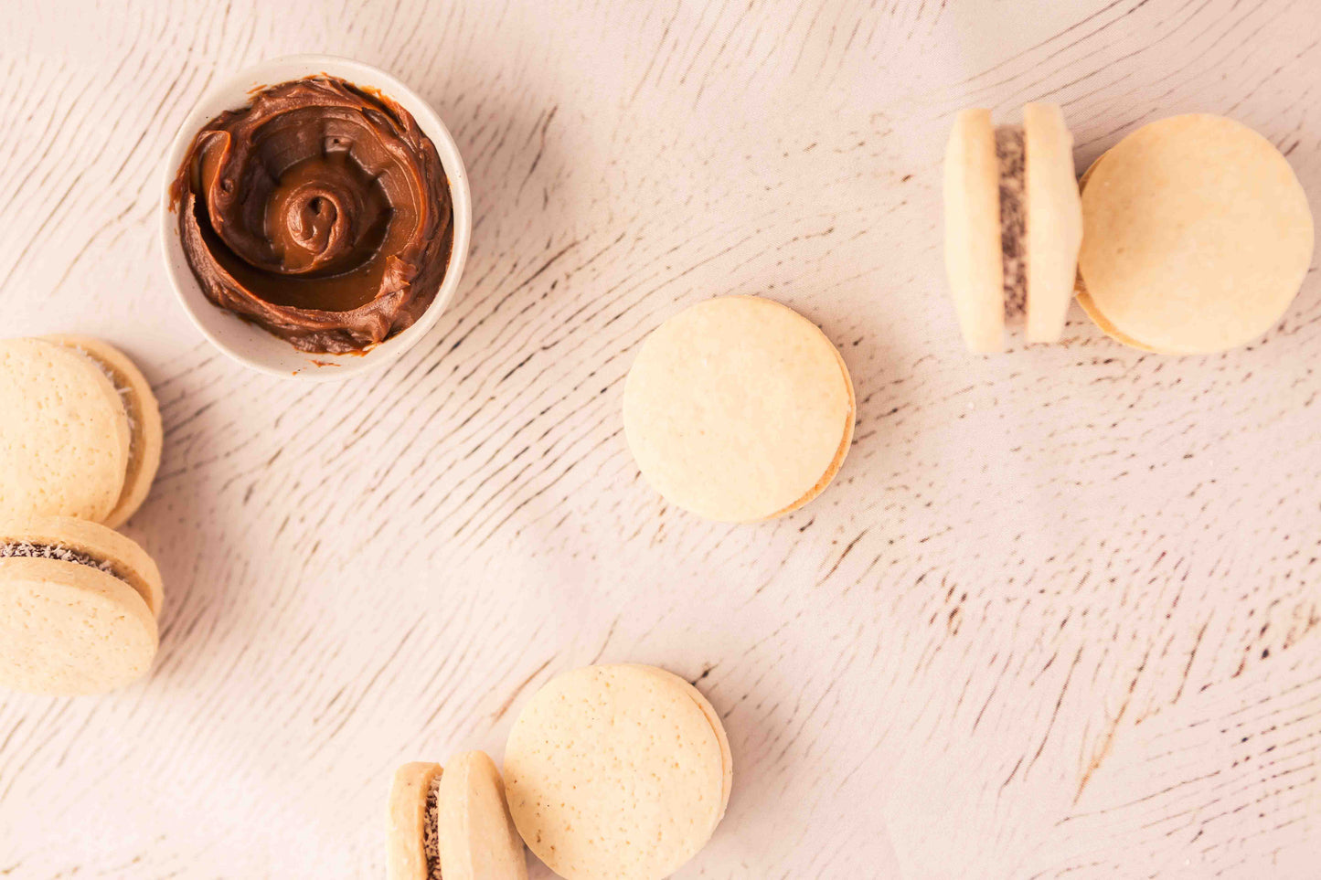 Alfajores rolled in coconut, served with a small pot of dulce de leche.