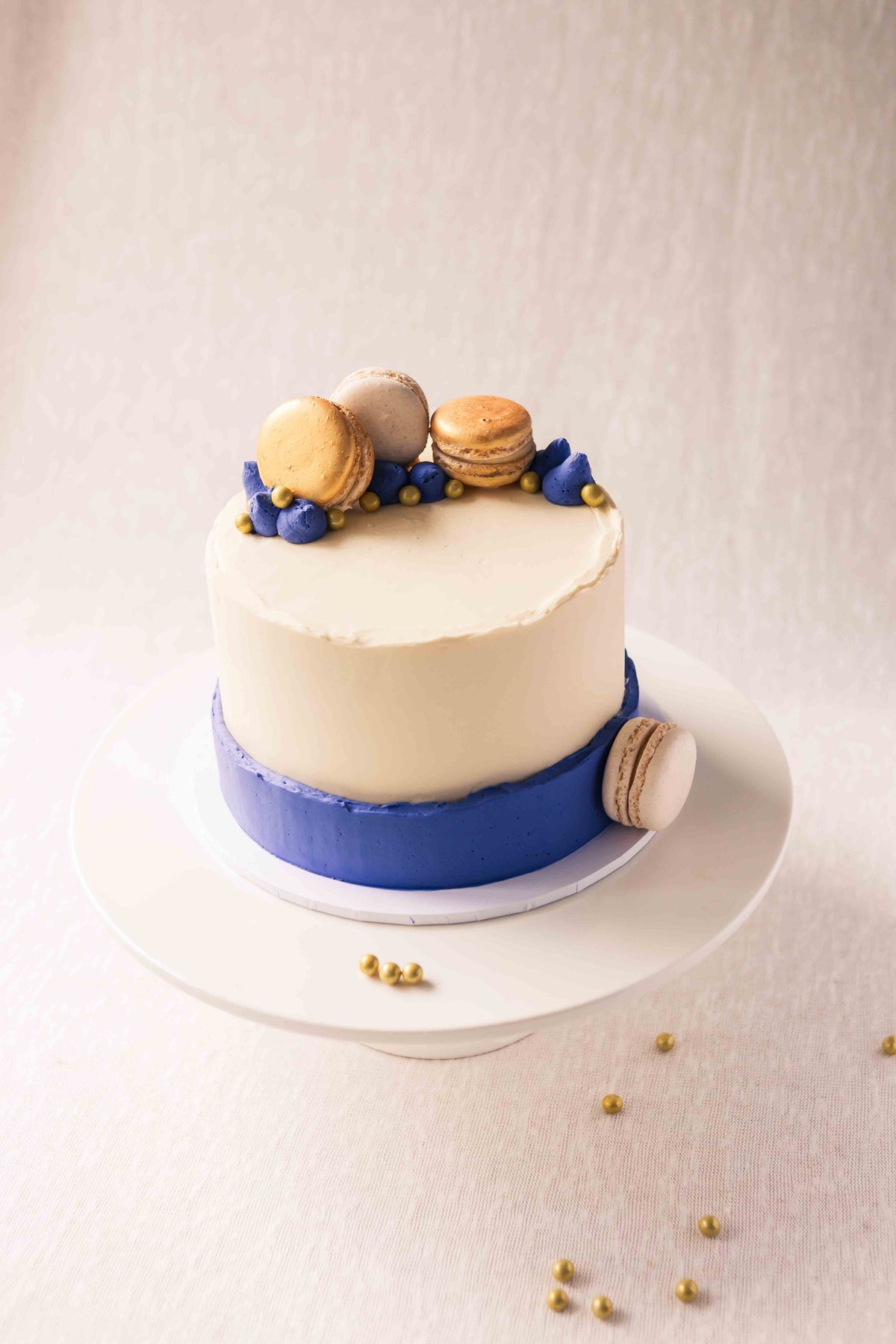 Signature buttercream cake with blue decoration and gold macarons, handcrafted in Perth, Western Australia.