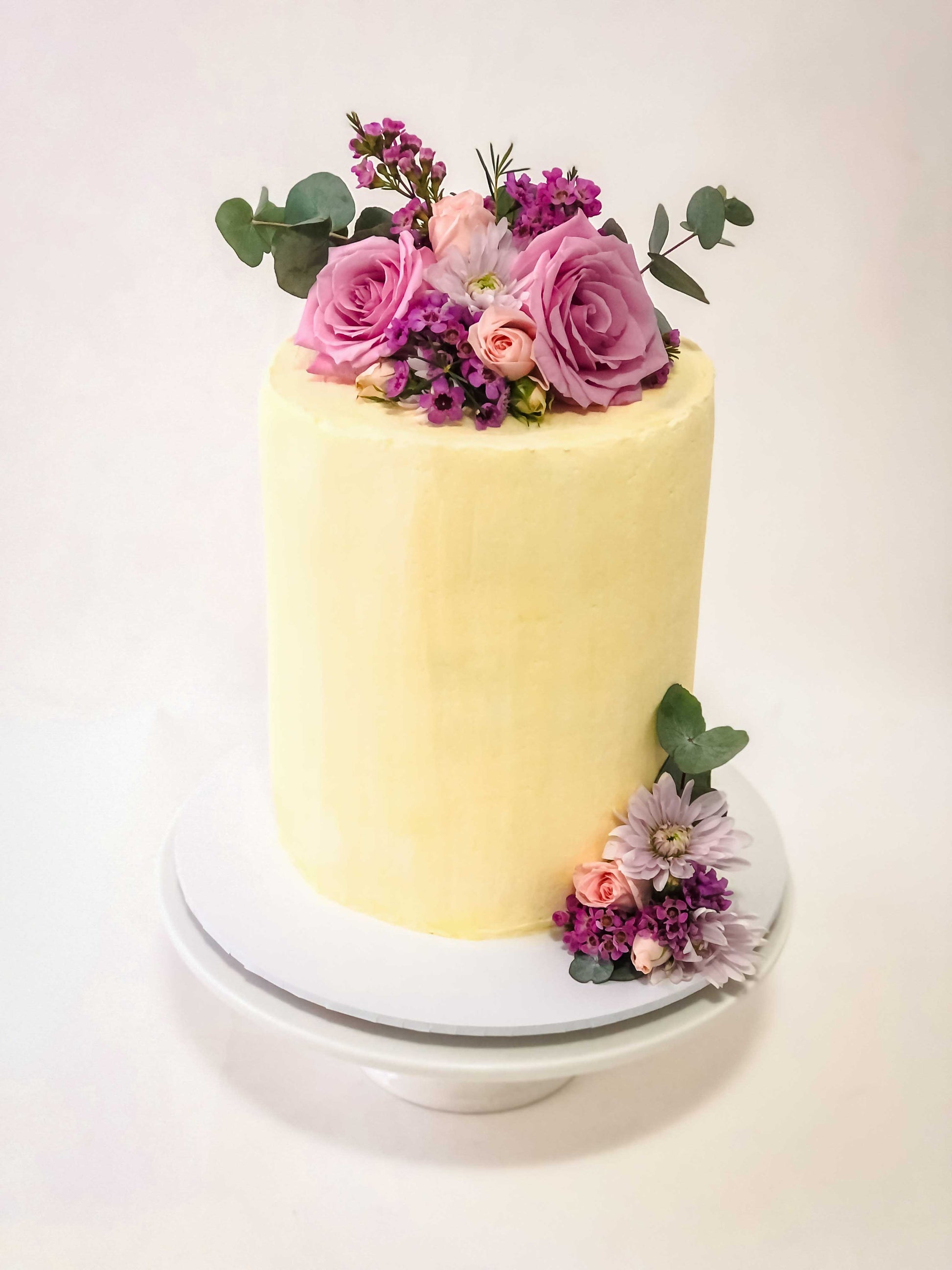 buttercream tall cake with  soft pink flowers