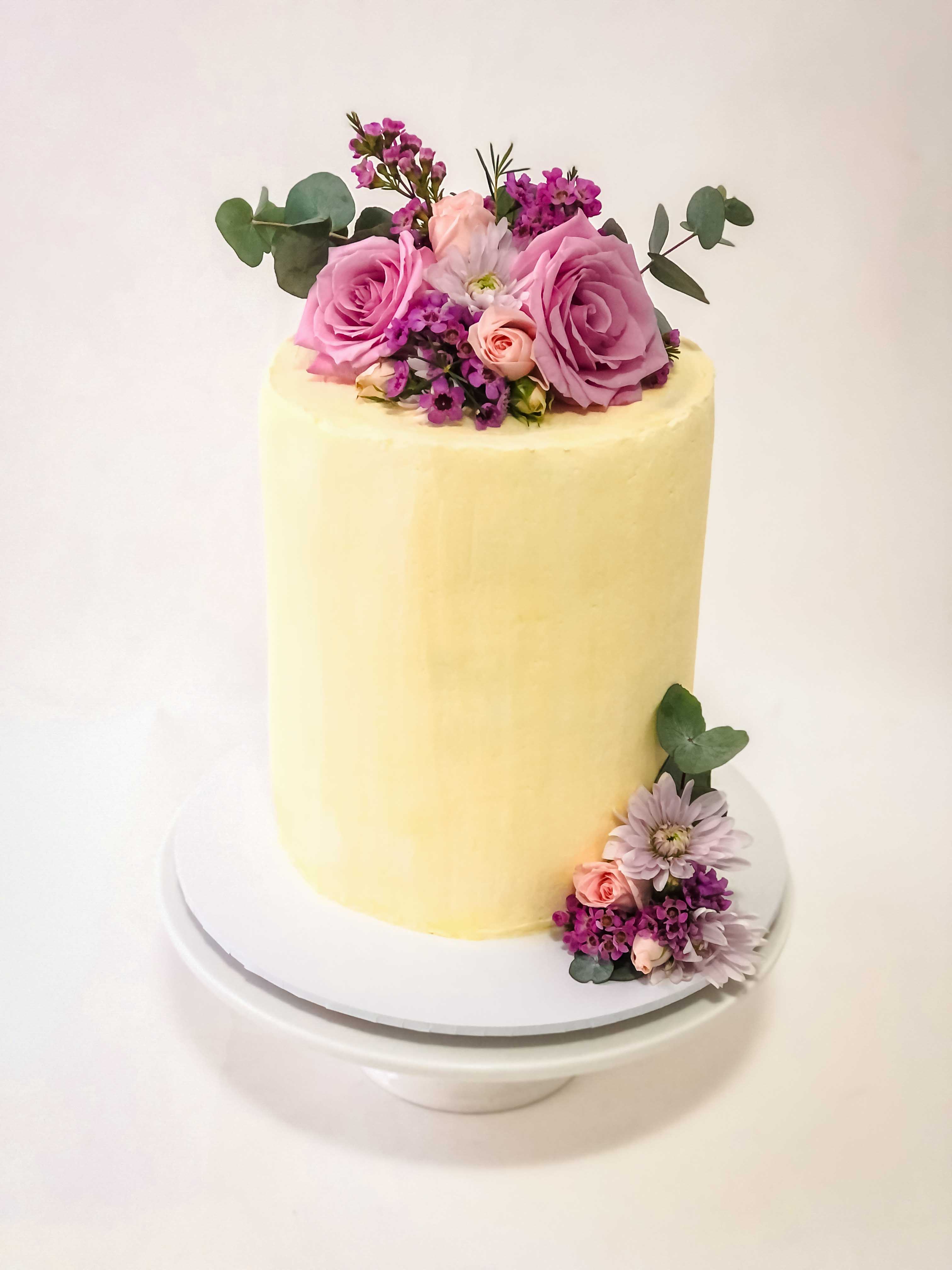 buttercream tall cake with  soft pink flowers