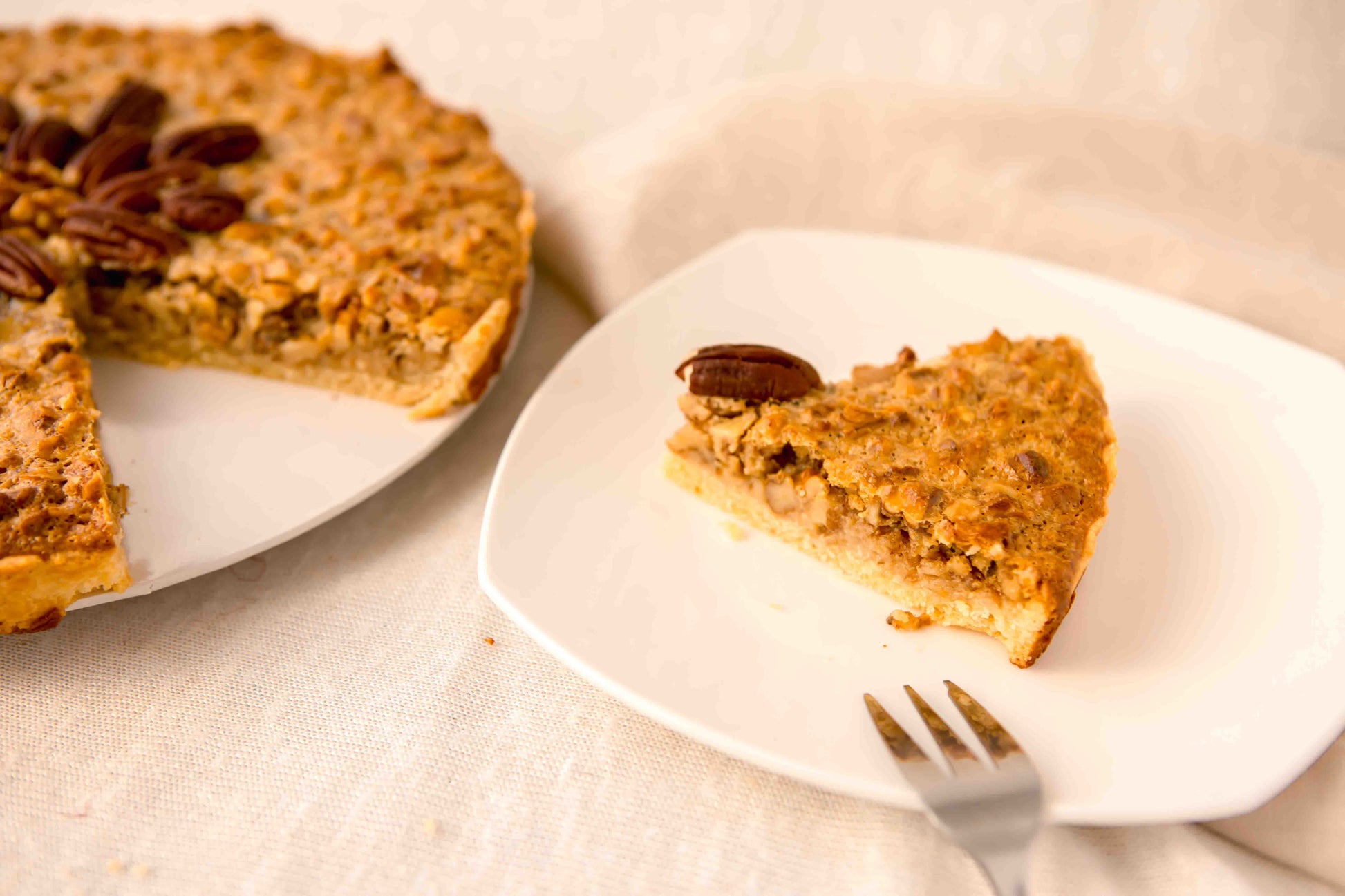 Walnut pie slice on a plate with a fork, showing the crunchy walnut filling, handmade in Perth.