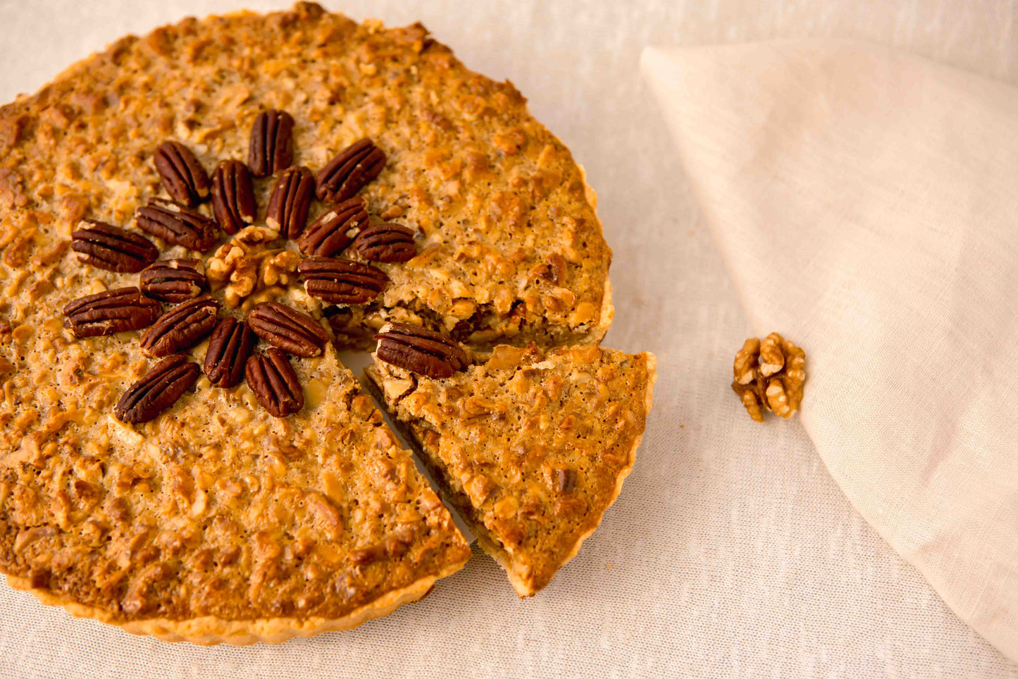 Pecan pie with a slice removed on with pecan